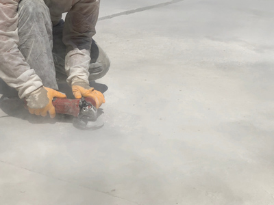 Arbeiter mit Flex bearbeitet Boden